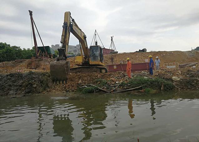 在永中街道度山村330国道龙湾段工程现场,施工人员正在对河道卡口进行