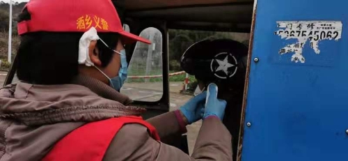市代表王桂香在卡点为进出村民测量体温.jpg