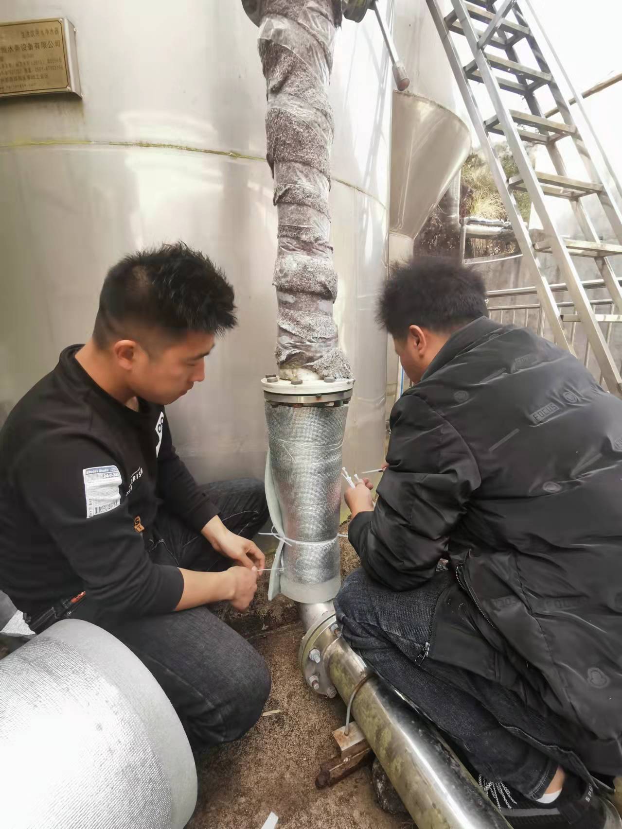 青田供水一线运维人员在巨浦乡湖云供水站对管网包上保温材料。.jpg