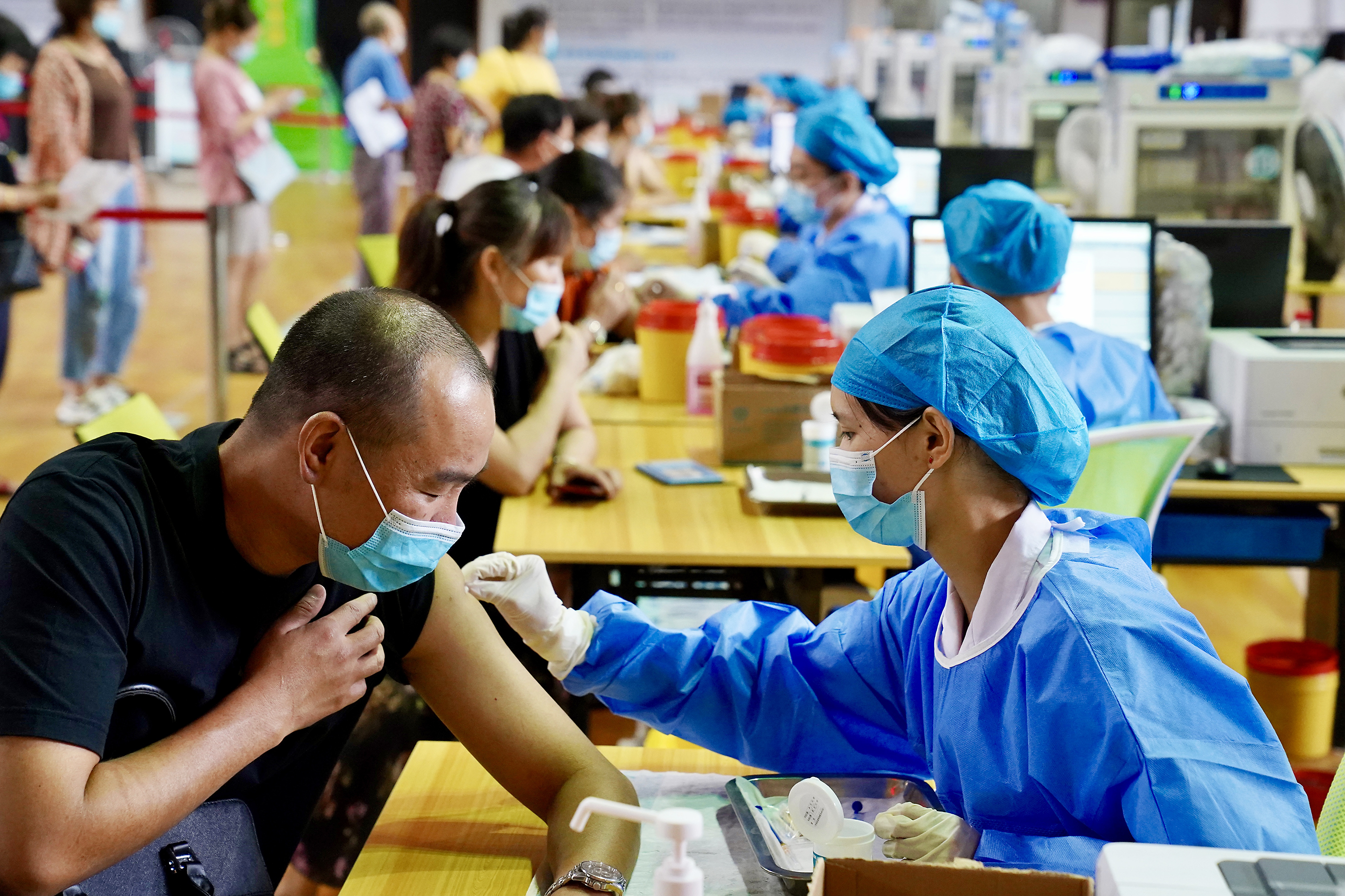 图为市民在市体育馆内进行疫苗接种.